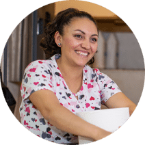 A woman smiling in a resident room.