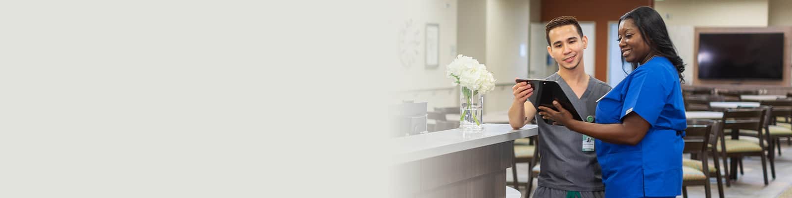 Two nurses looking at a patient chart together.